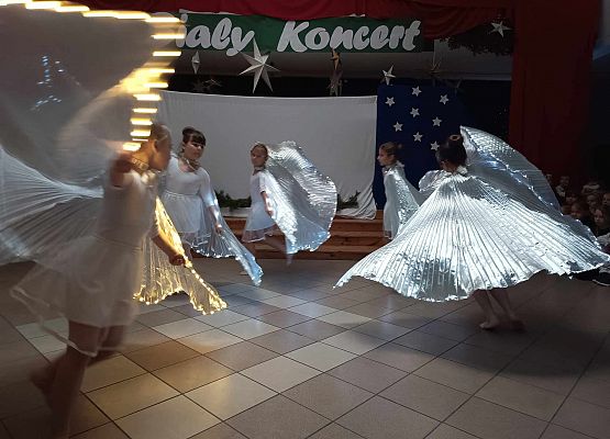 taniec dziewczynek z klas 1-3 ze świecącymi skrzydłami