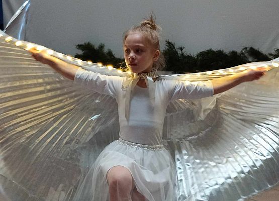 taniec dziewczynek z klas 1-3 ze świecącymi skrzydłami