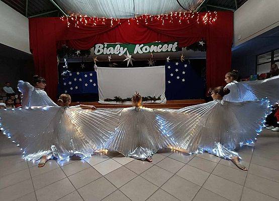 taniec dziewczynek z klas 1-3 ze świecącymi skrzydłami