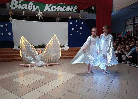 taniec dziewczynek z klas 1-3 ze świecącymi skrzydłami