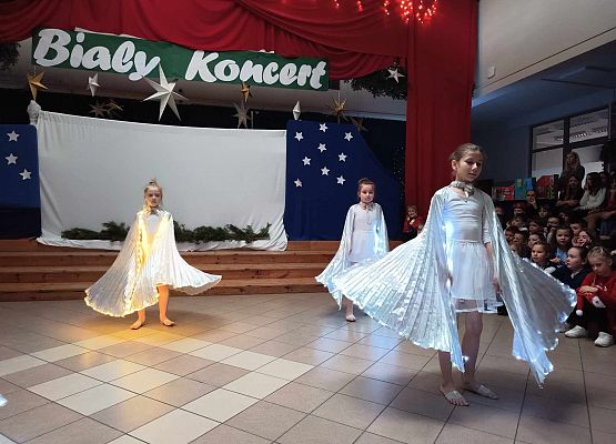 taniec dziewczynek z klas 1-3 ze świecącymi skrzydłami