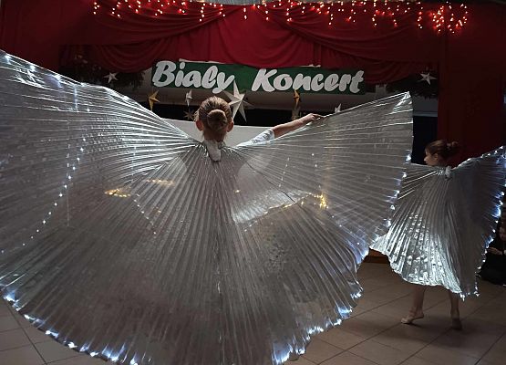 taniec dziewczynek z klas 1-3 ze świecącymi skrzydłami