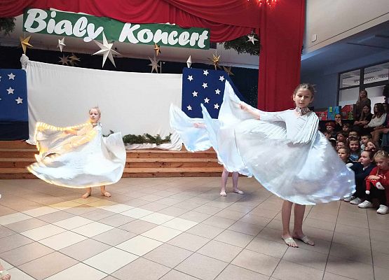 taniec dziewczynek z klas 1-3 ze świecącymi skrzydłami