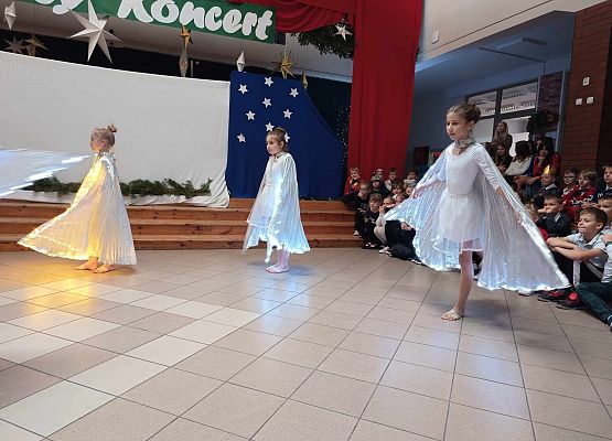 taniec dziewczynek z klas 1-3 ze świecącymi skrzydłami