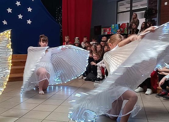 taniec dziewczynek z klas 1-3 ze świecącymi skrzydłami