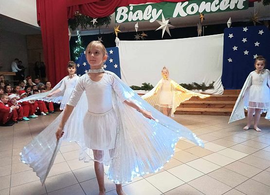 taniec dziewczynek z klas 1-3 ze świecącymi skrzydłami