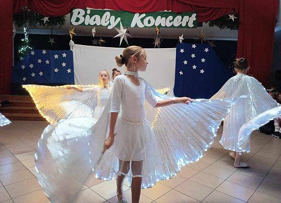 taniec dziewczynek z klas 1-3 ze świecącymi skrzydłami