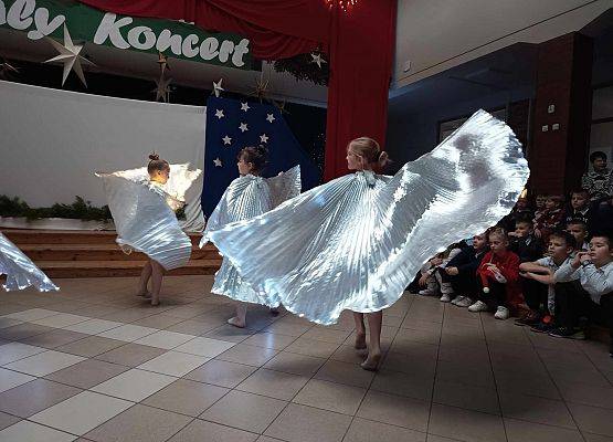 taniec dziewczynek z klas 1-3 ze świecącymi skrzydłami