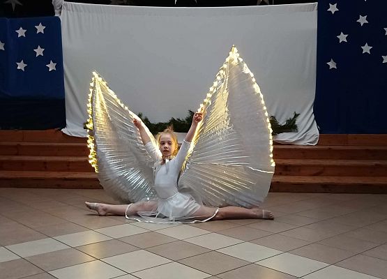 taniec dziewczynek z klas 1-3 ze świecącymi skrzydłami
