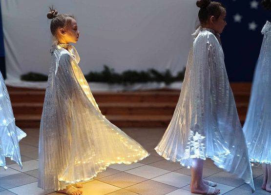 taniec dziewczynek z klas 1-3 ze świecącymi skrzydłami