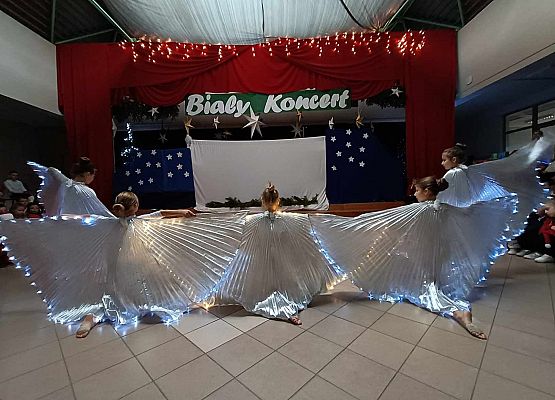 taniec dziewczynek z klas 1-3 ze świecącymi skrzydłami