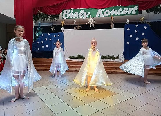 taniec dziewczynek z klas 1-3 ze świecącymi skrzydłami