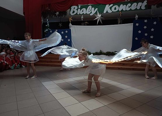 taniec dziewczynek z klas 1-3 ze świecącymi skrzydłami