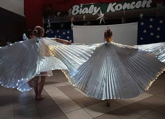 taniec dziewczynek z klas 1-3 ze świecącymi skrzydłami