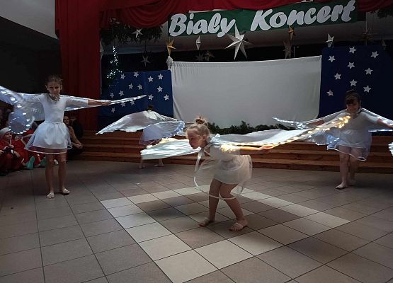 taniec dziewczynek z klas 1-3 ze świecącymi skrzydłami