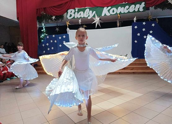 taniec dziewczynek z klas 1-3 ze świecącymi skrzydłami