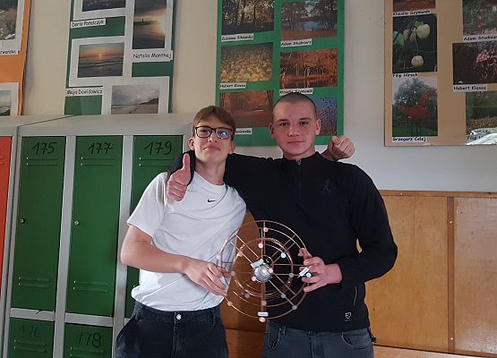 Kuba i Franek prezentują wykonany przez siebie model budowy atomu.