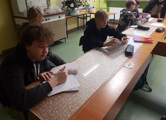 Chłopcy rozwiązują zadania dotyczące wodorotlenków.