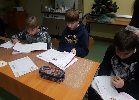 Chłopcy wyszukują informacje potrzebne do rozwiązania zadania.