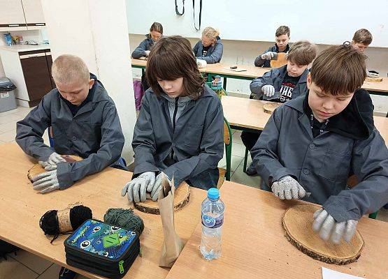 chłopcy szlifują deseczki