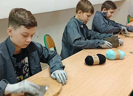 chłopcy szlifują deseczki