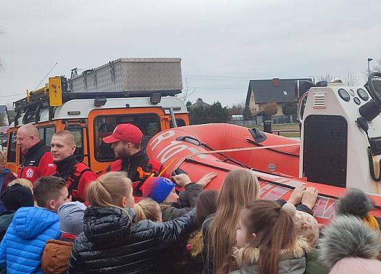 dzieci z 1-3 na dworzu oglądają łódkę ratowniczą