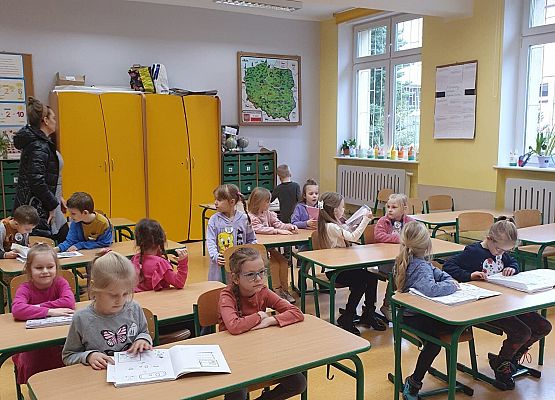 dzieci ogladaja zeszyty klas I