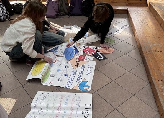 Uczennice tworzą informacje na białym arkuszu papieru