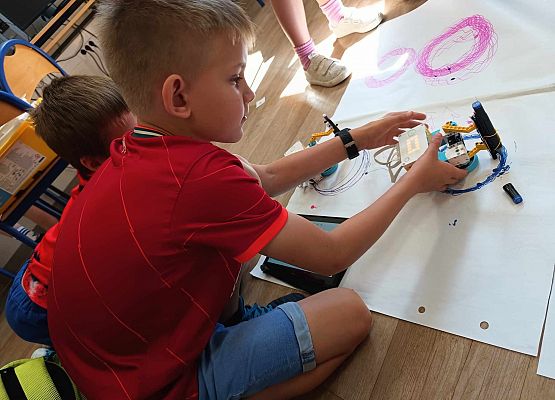 chłopcy  sprawdzają działanie robota