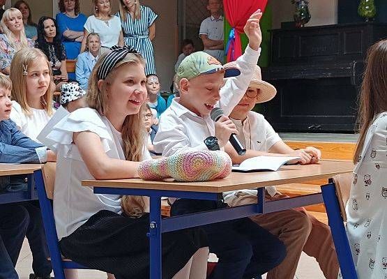 występ artystyczny klas 3 - uczniowie w ławkach