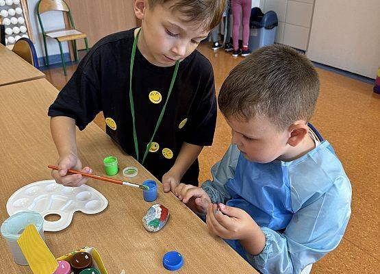 chłopcy malują kamyki