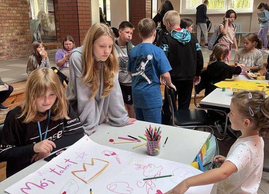 Plakat z napisem mój talent , uczniowie malują na nim
