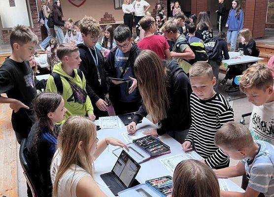 Uczniowie kolorują kartki i skanują je tabletami