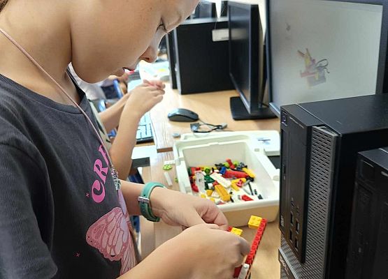 dziewczynka buduje z klocków