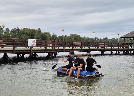 chłopcy płyną tratwą