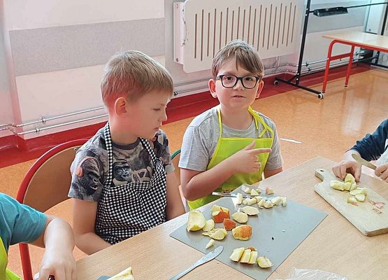 chłopcy kroją owoce