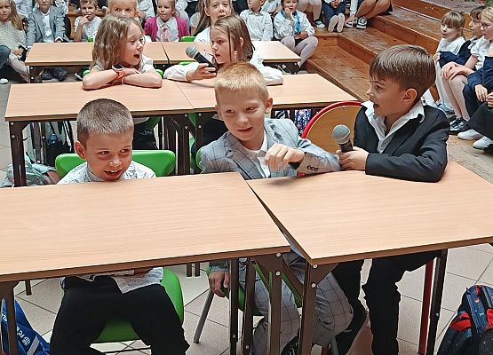 występ klas 1 dzieci siedzą w ławkach