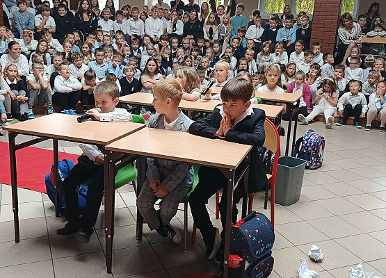 występ klas 1 dzieci siedzą w ławkach