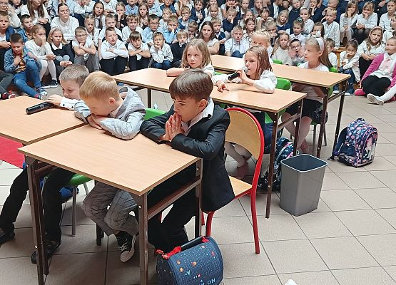 występ klas 1 dzieci siedzą w ławkach