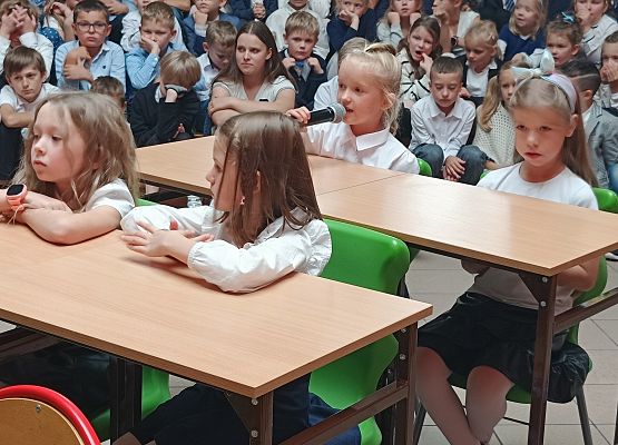 występ klas 1 dzieci siedzą w ławkach