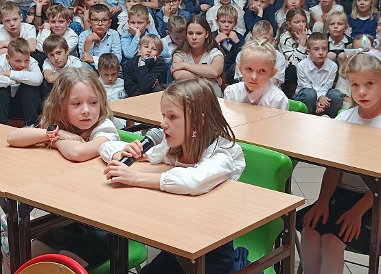 występ klas 1 dzieci siedzą w ławkach