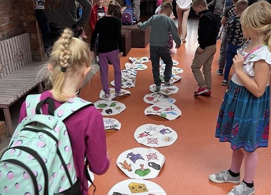 Na podłodze leży okrągłe duże dooble, uczniowie grają w niego