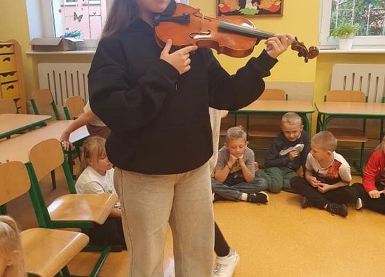 Alicja pokazuje dzieciom skrzypce