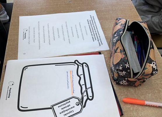 Na stole leżą karty pracy na których narysowane są słoiki .