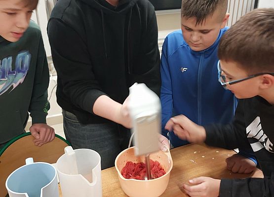 chłopcy blendują truskawki