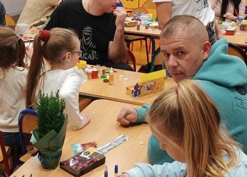 rodzice wspólnie z dziećmi wykonują ozdoby