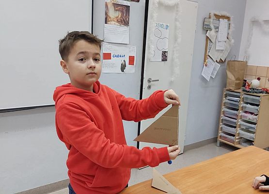 chłopiec pokazuje trójkąt