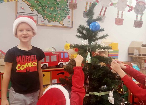 szczęśliwe dzieci ubierają choinkę