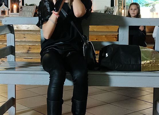 dziewczynka siedzi na ławce i rozmawia przez telefon