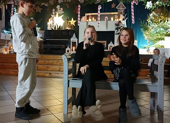 dziewczynki siedzą na ławce i rozmawiają z chłopcem